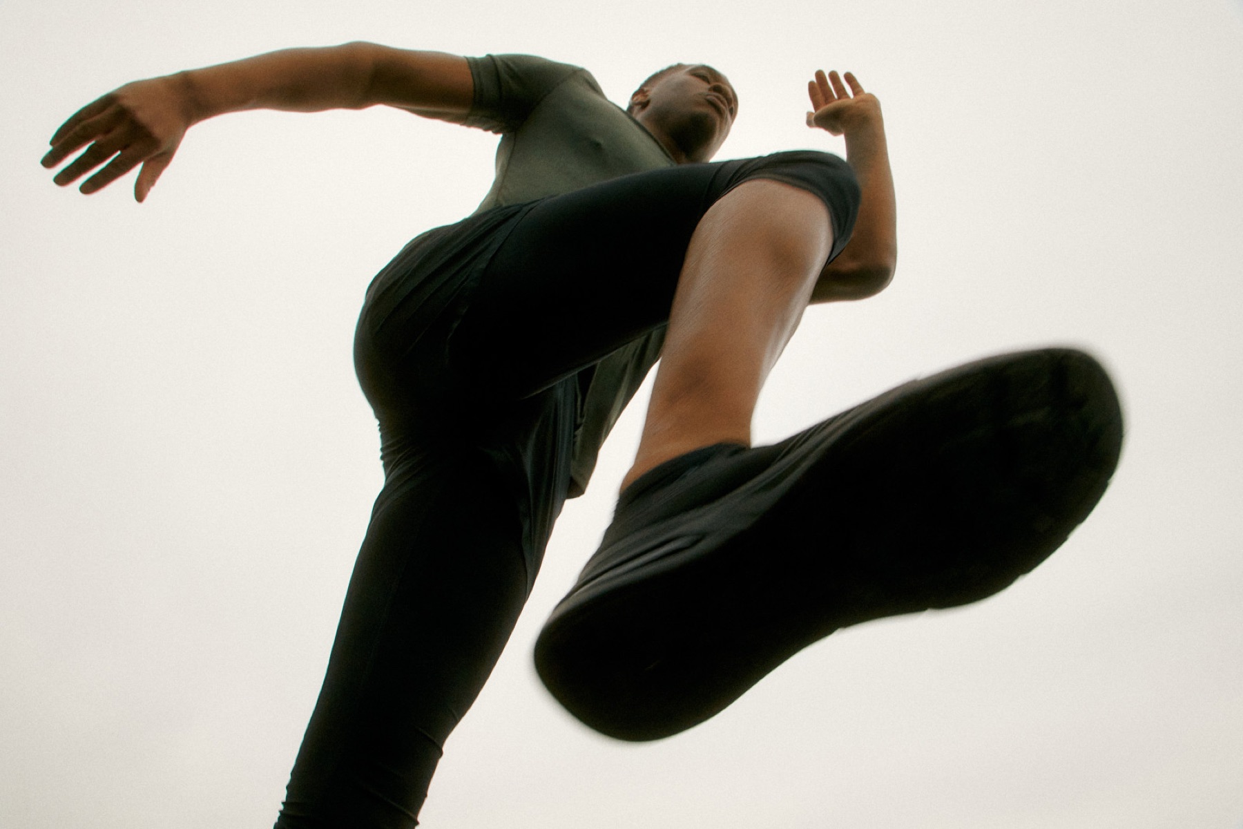 An athlete jumping above the camera during an outdoor warm-up